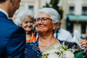 ältere Frau graue Haare Oma mit Brille schaut weinerlich zu Bräutigam
