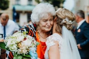 ältere Frau graue Haare Oma umarmt Braut und weint