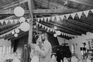 Brautpaar tanzt lacht miteinander in Feierlocation Wimpelkette Lampion