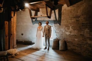 Brautpaar steht in alter Mühle Blick nach oben