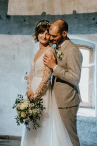 Bräutigam streichelt Arm der Braut Köpfe zueinander geneigt
