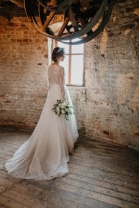 Braut dreht Rücken zur Kamera Seitenprofil Brautkleid mit Schleppe