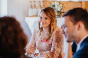 Frau lächelt am Tisch Hochzeitsfeier