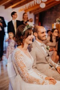 Braut mit Blumenkranz lächelt Hochzeitsfeier Bräutigam