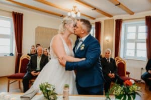 Braut Bräutigam küssen sich Trauung Standesamt Gäste