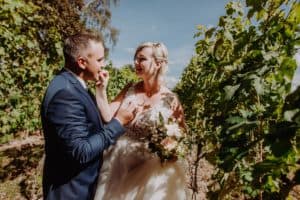 Braut füttert Bräutigam Weinberg Weinanlage