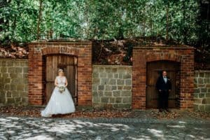 Braut und Bräutigam stehen in Tür Weinkeller Kopfsteinpflaster