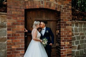 Braut und Bräutigam küssen sich Brautpaar steht in Tür