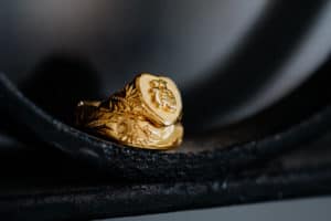 Detailaufnahme goldene Ringe mit floralen Elementen und Schriftzeichen